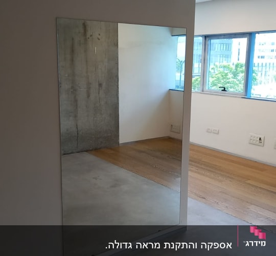 מראה גדולה על קיר לבן בחדר פנימי